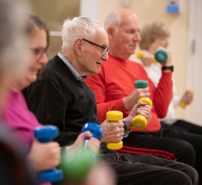 Two men and women in weights and fitness class